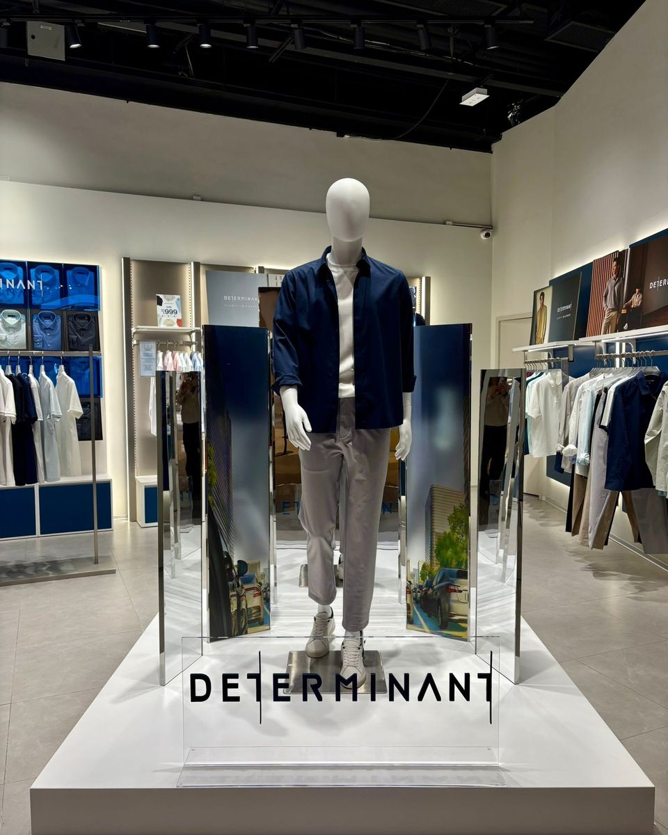 DETERMINANT window display: a mannequin framed by mirrored fins on a white plinth