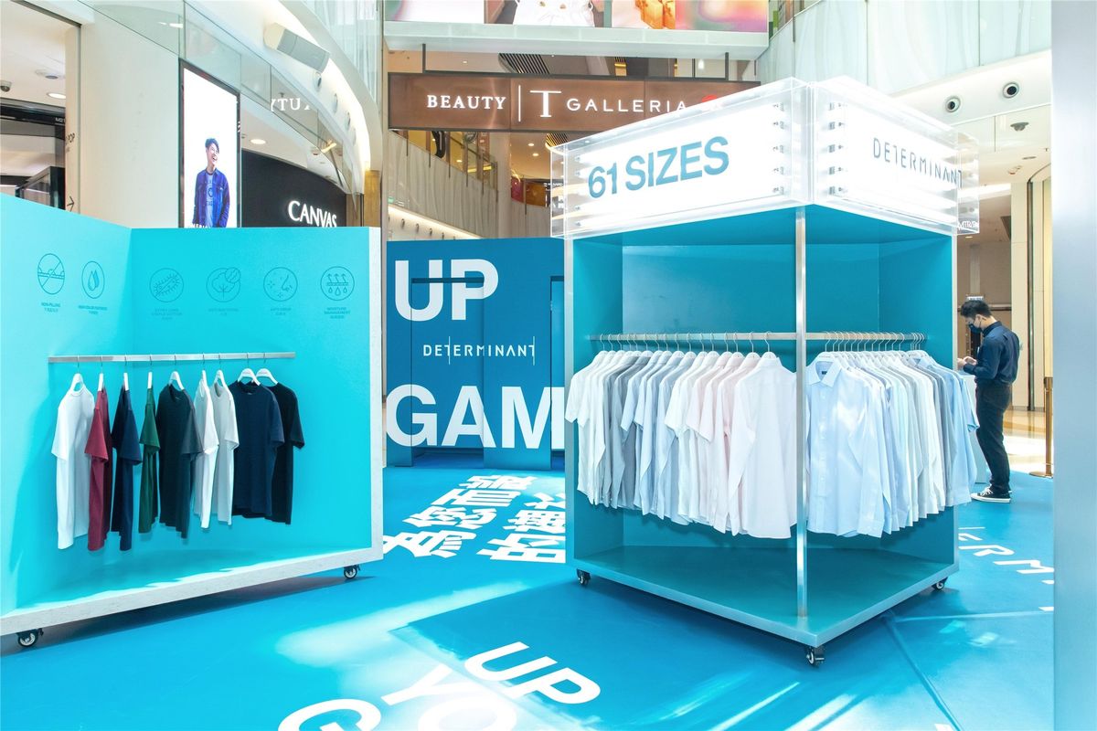 DETERMINANT 61 SIZES pop-up at eye level: shirt rails under a lightbox header