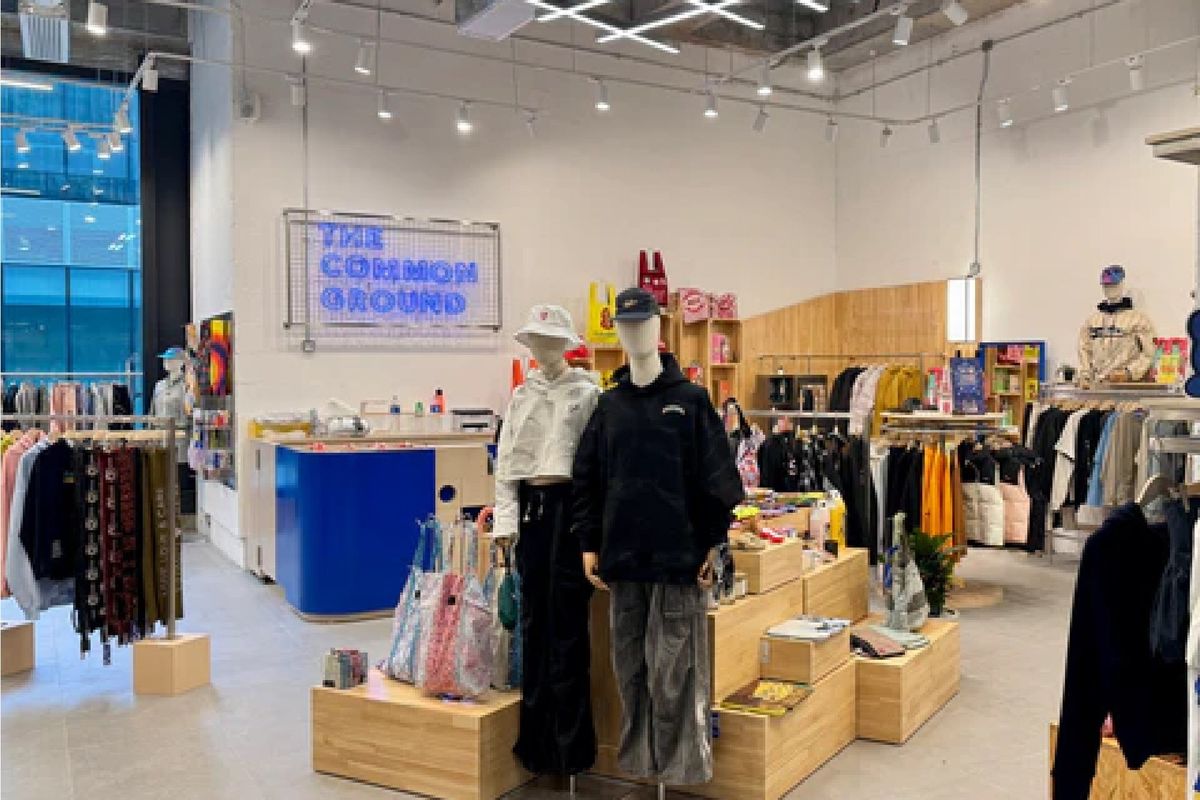 The Common Ground store with neon sign, grid light ceiling and timber crate plinths
