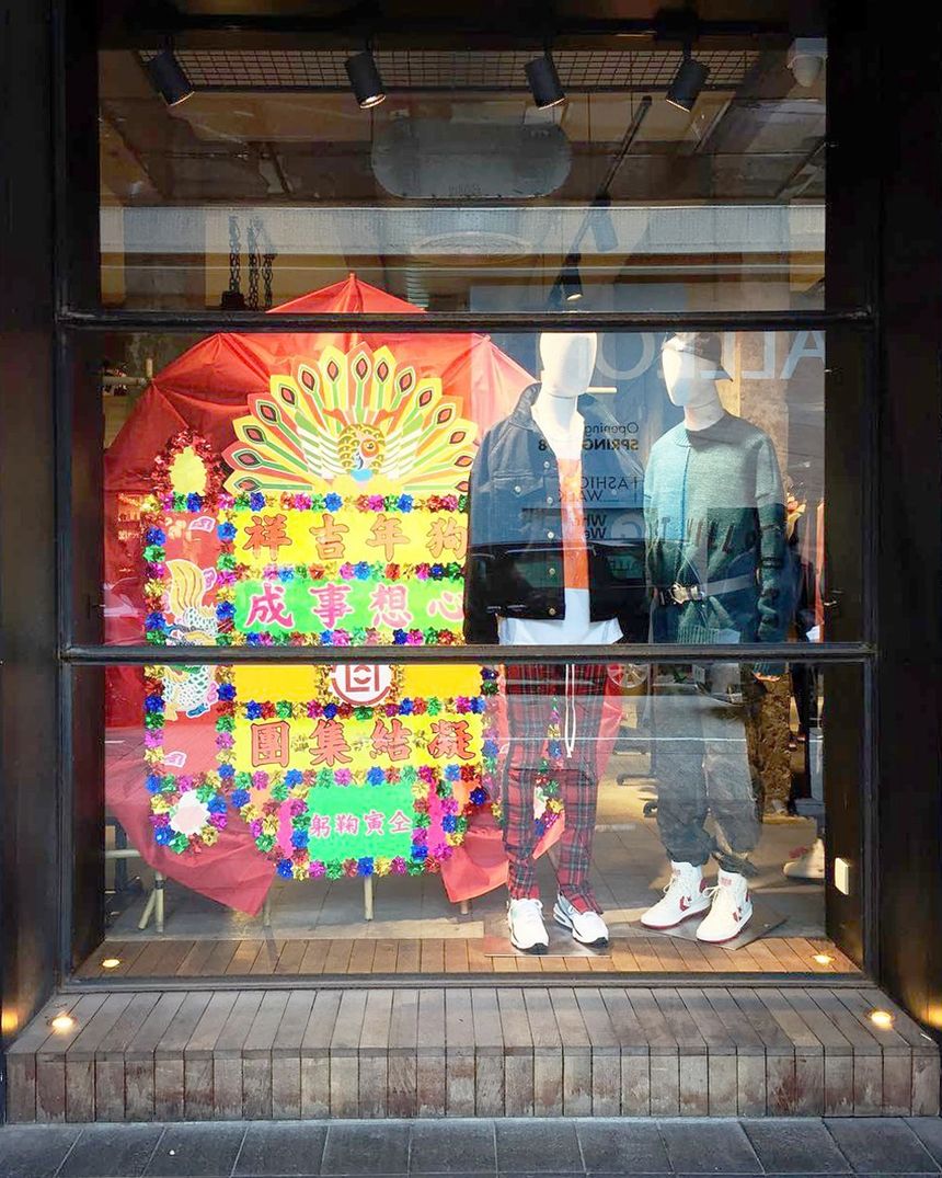 Festive window: colourful illustrated panel behind mannequins